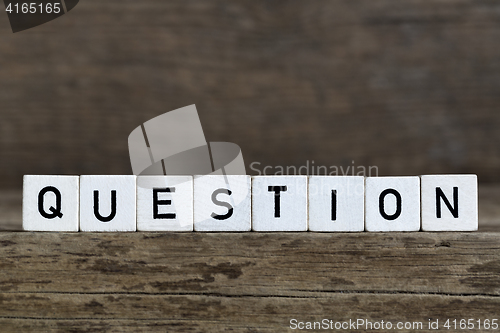 Image of Question, written in cubes on wooden background