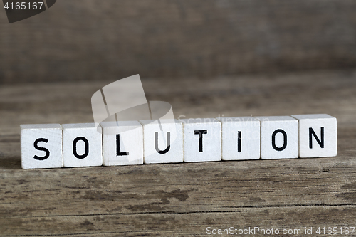 Image of Solution, written in cubes on wooden background