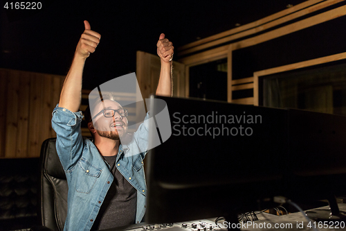 Image of man at mixing console in music recording studio