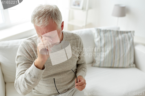 Image of senior man suffering from headache at home