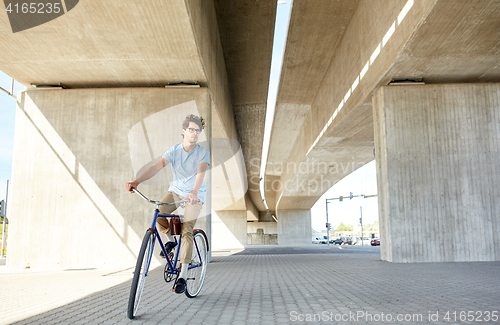 Image of young hipster man riding fixed gear bike