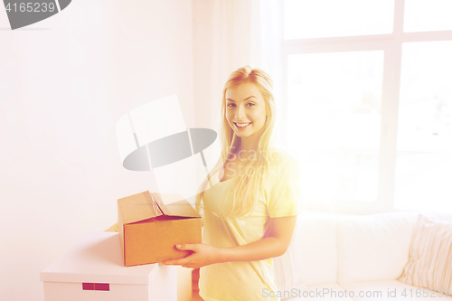 Image of smiling young woman with cardboard box at home