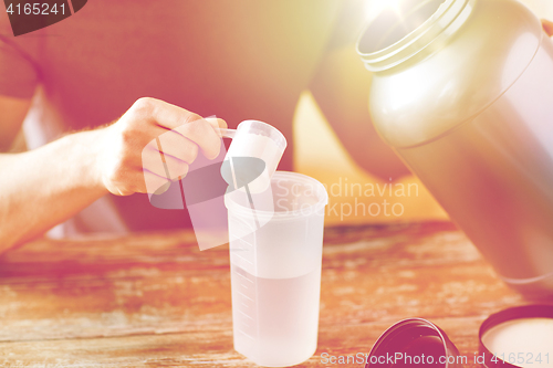 Image of close up of man with protein shake bottle and jar