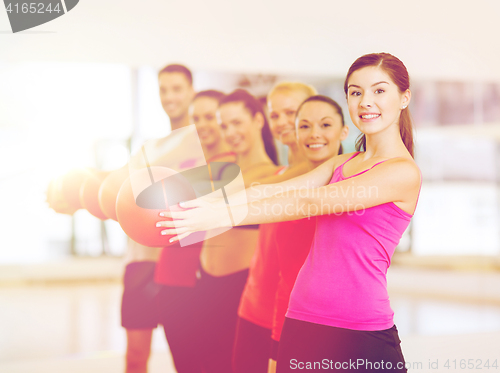 Image of group of smiling people working out with ball