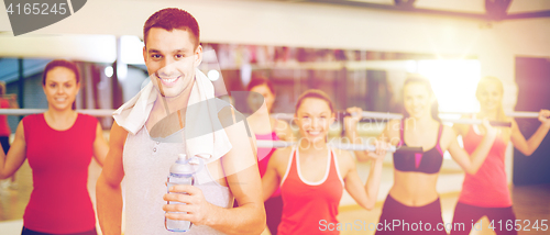 Image of smiling trainer in front of group of people