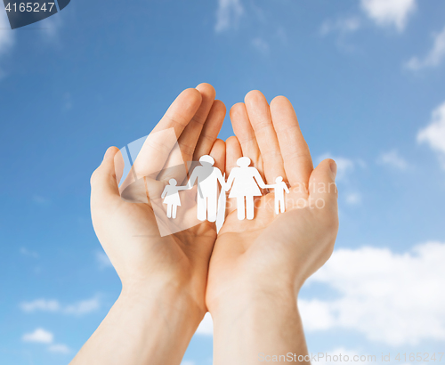 Image of close up of hands holding paper family pictogram