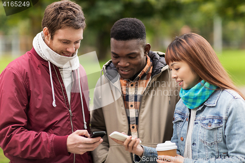 Image of happy friends with smartphone and coffee outdoors