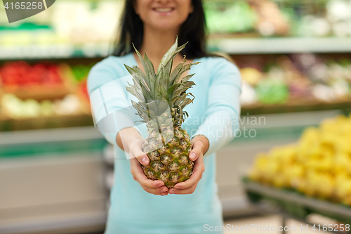 Image of woman with pineapple at grocery store