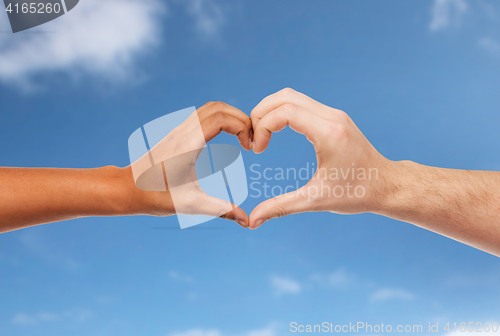 Image of woman and man hands making heart symbol