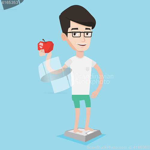 Image of Man standing on scale and holding apple in hand.