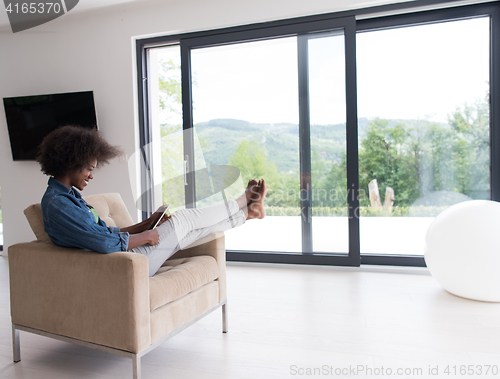 Image of african american woman at home with digital tablet