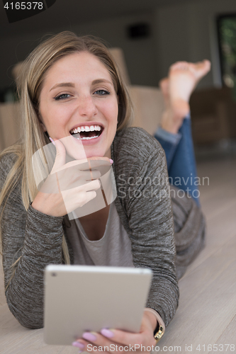 Image of young women used tablet computer on the floor