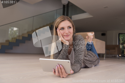 Image of young women used tablet computer on the floor