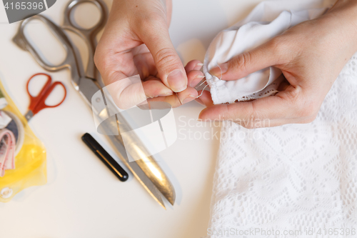 Image of Girl unpick fabric on table