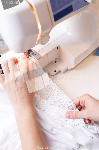 Image of Woman scribbles fabric on sewing-machine
