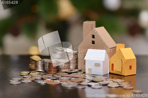 Image of Paper house and stacks of coins standing