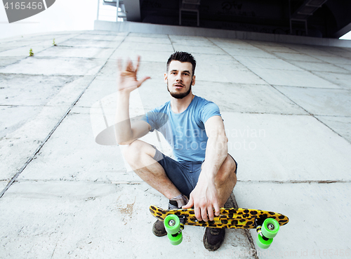 Image of young handsome real hipsrter guy bearded staying under the bridg