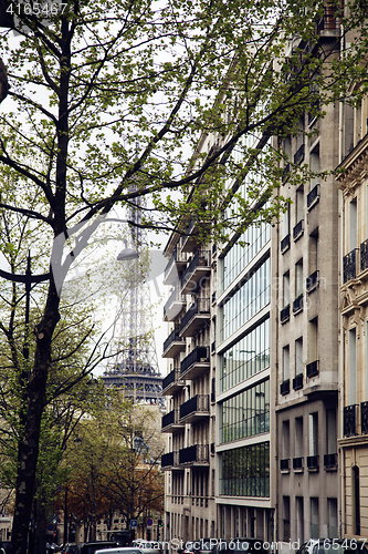 Image of french paris street with Eiffel Tower in perspective trought trees