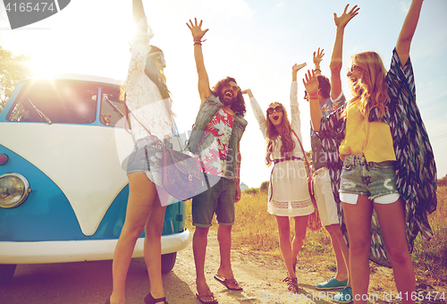 Image of smiling hippie friends having fun over minivan car