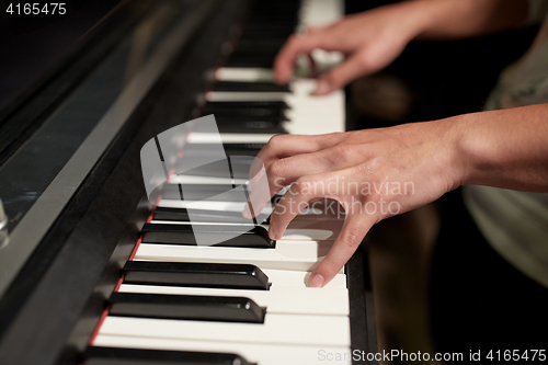 Image of close up of hands playing piano