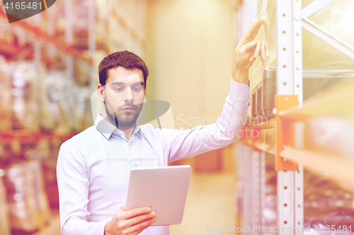 Image of businessman with tablet pc at warehouse