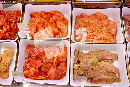 Image of marinated meat in bowls at grocery stall