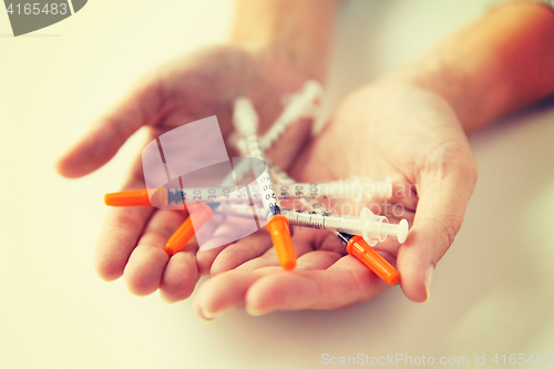 Image of close up of woman hands holding insulin syringes