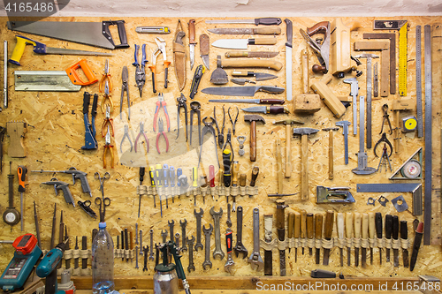 Image of work tools hanging on wall at workshop