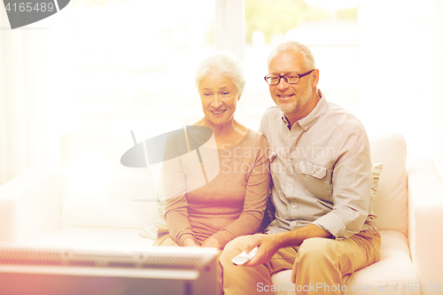 Image of happy senior couple watching tv at home