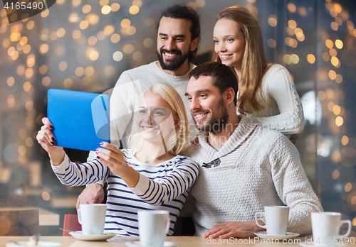 Image of happy friends with tablet pc taking selfie at cafe