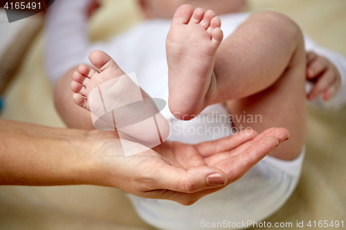 Image of close up of newborn baby feet in mother hands