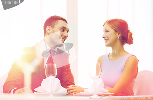 Image of smiling couple looking at each other at restaurant