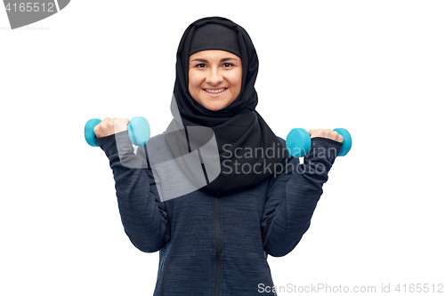 Image of muslim woman in hijab with dumbbells doing fitness