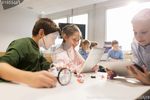 Image of kids with tablet pc programming at robotics school