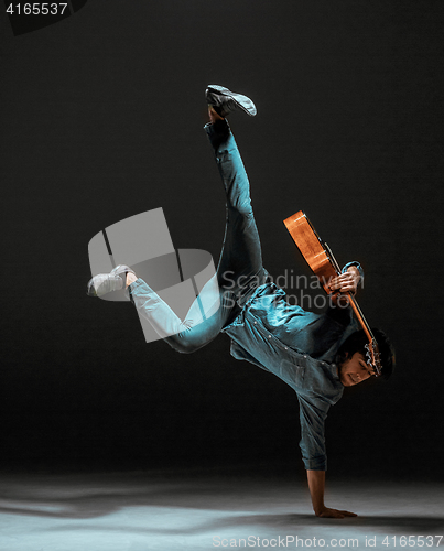 Image of Cool guy standing with guitar on dark background