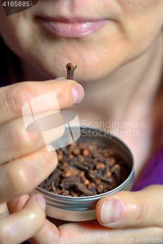 Image of Woman chew dried clove spice