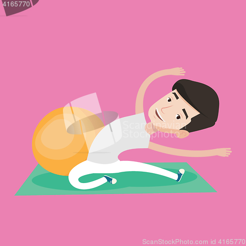 Image of Young man exercising with fitball.