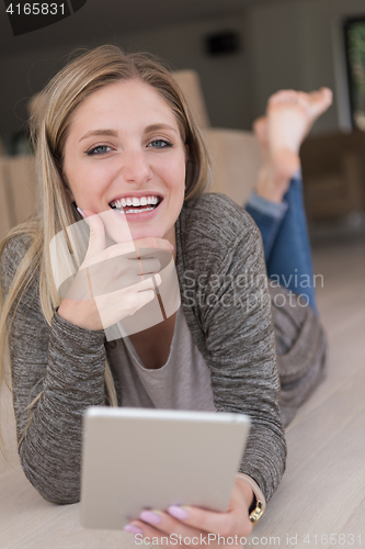 Image of young women used tablet computer on the floor