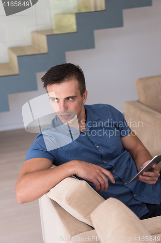 Image of young man using a tablet at home