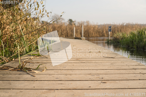 Image of Wooden pier by a lake in autumn