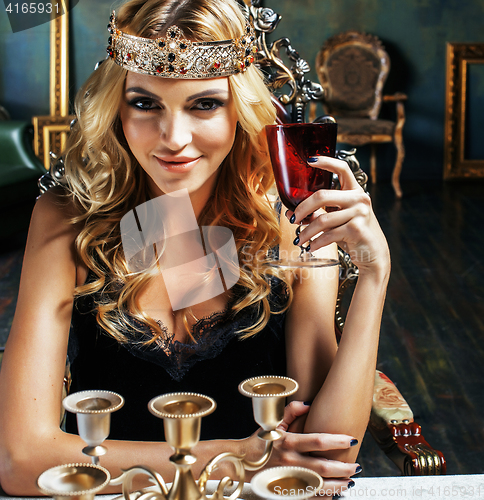 Image of young blond woman wearing crown in fairy luxury interior with em