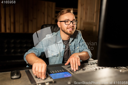 Image of man at mixing console in music recording studio