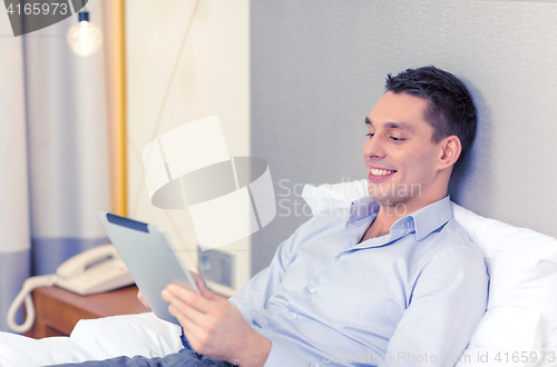 Image of happy businesswoman with tablet pc in hotel room