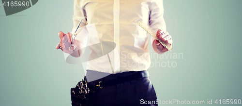 Image of close up of male stylist with scissors at salon