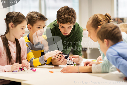 Image of happy children building robots at robotics school