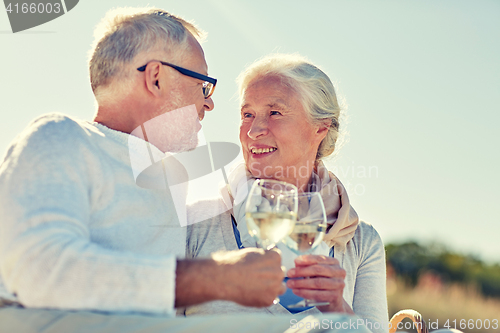 Image of happy senior couple having picnic on summer beach