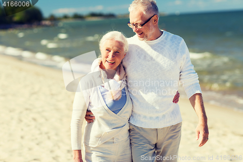 Image of happy senior couple hugging on summer beach