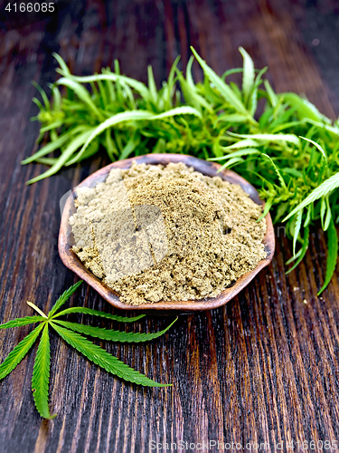 Image of Flour hemp in clay bowl with green leaf on board