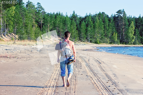 Image of Man Is Traveling Barefoot Along The Beach