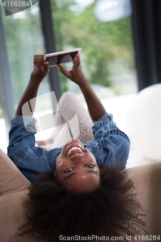 Image of african american woman at home with digital tablet